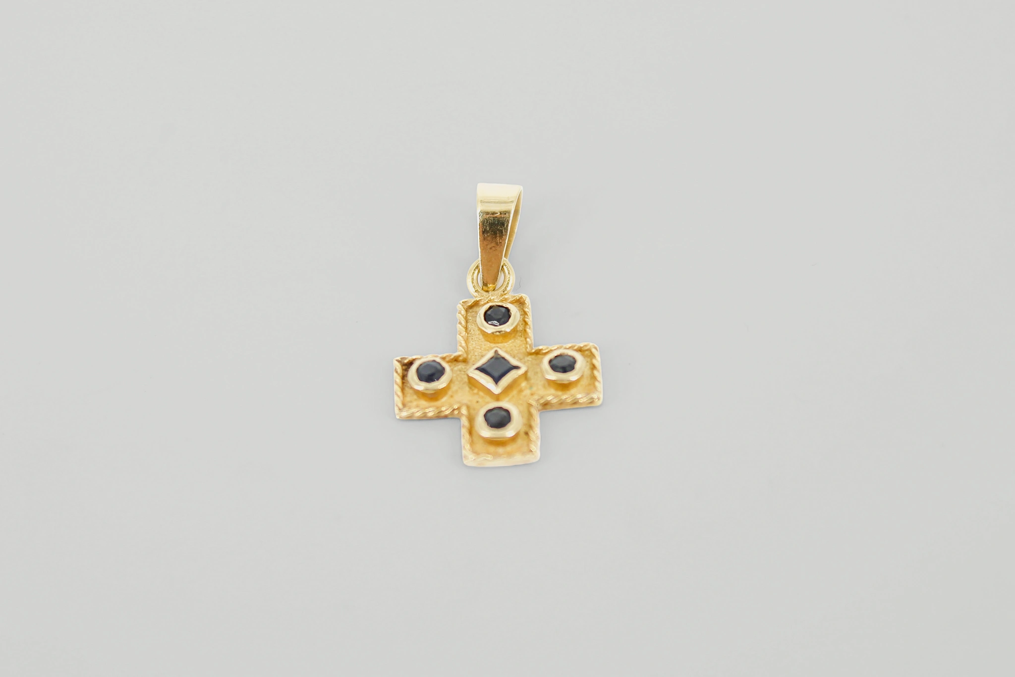 Cruz de oro de 18k con piedras azules